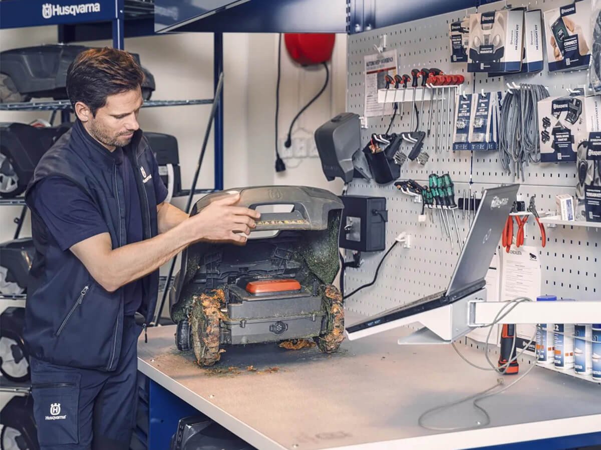 Baumaschinenmechatroniker repariert einen rasenmaeher